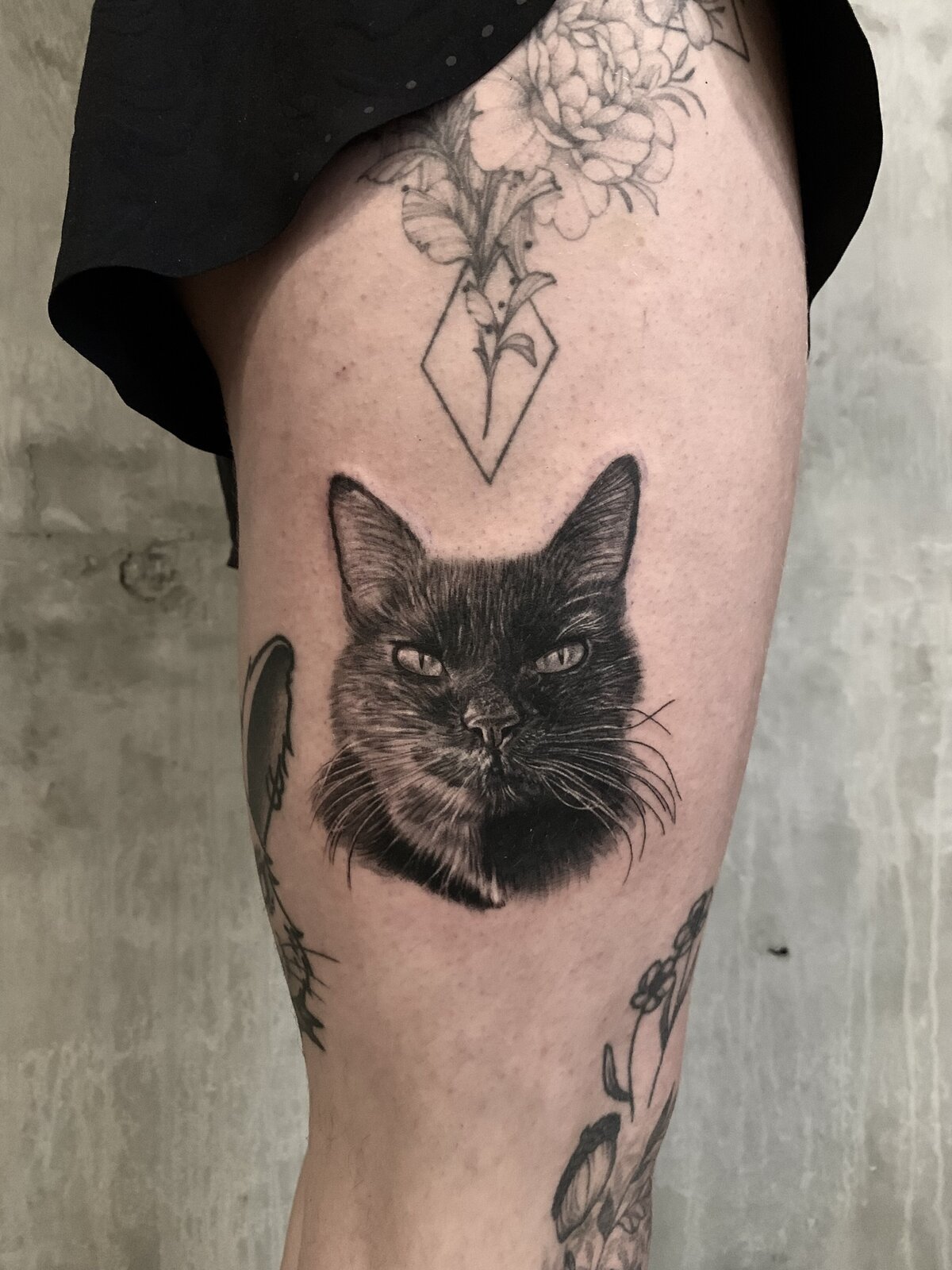 Realistic black and grey cat pet portrait tattoo by Carli Hall